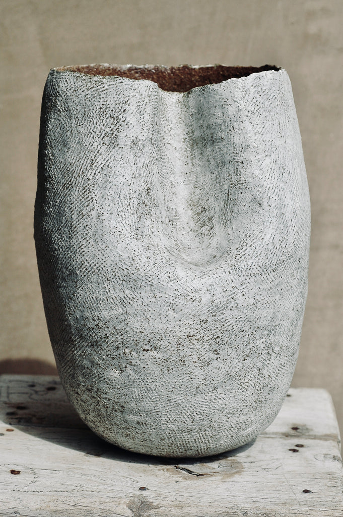 This piece is a hand-built, coiled, clay vessel. Mid-fired. Glazed on the interior. Textured exterior is finished in clay slip. Dimensions are 8x8x11 inches.  Edit alt text