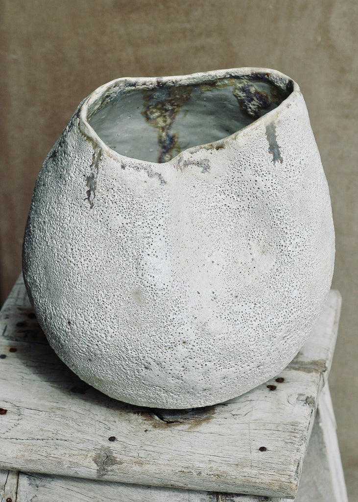 This piece is hand-built, coiled. The interior is finished is white glaze. The exterior is finished in a volcanic glaze. Where the two glazes meet resulted in warm tones. The piece measures 9 inches in diameter and 9.5 inches tall.